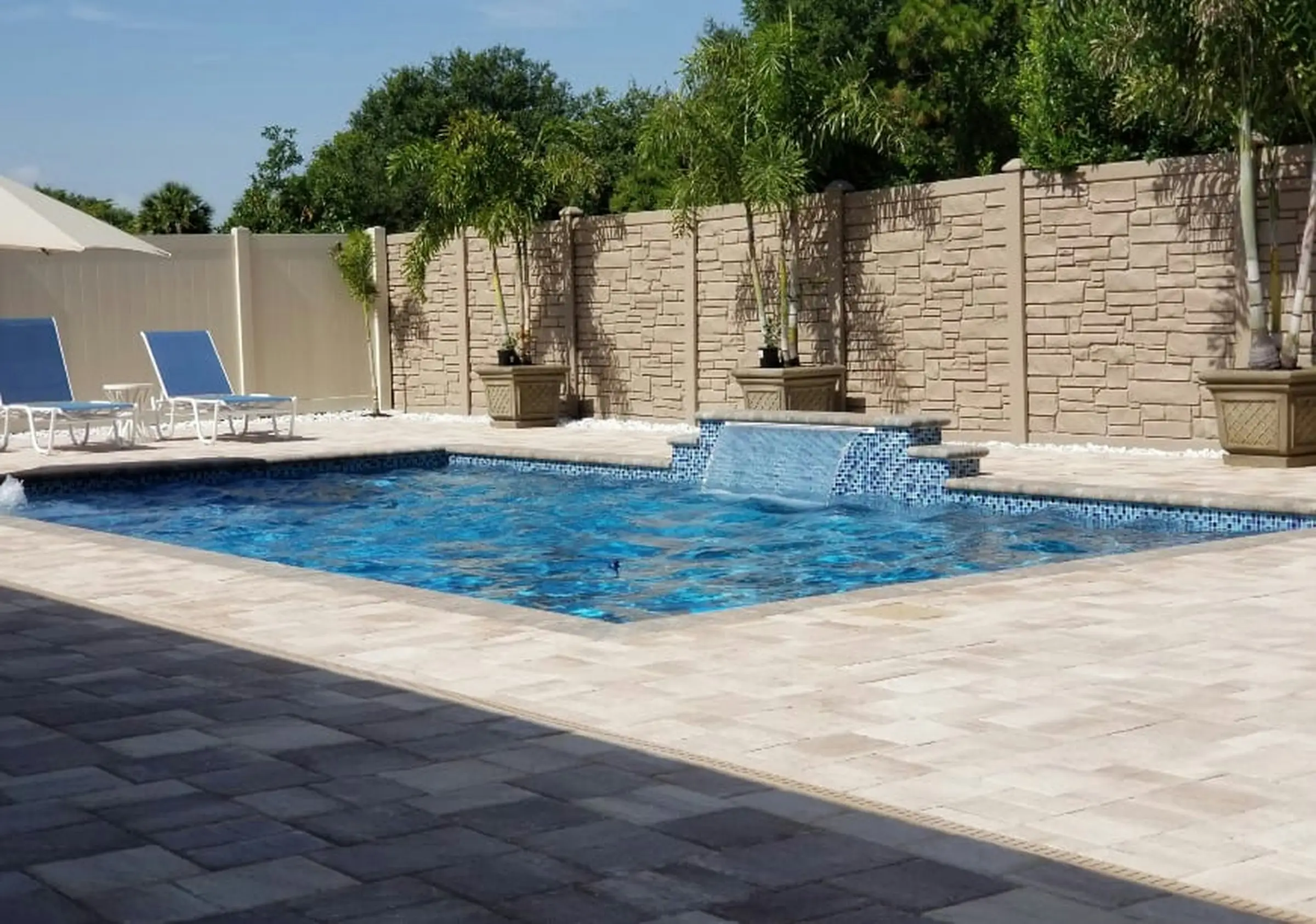 Piscina con cascadas de agua desde un muro revestido