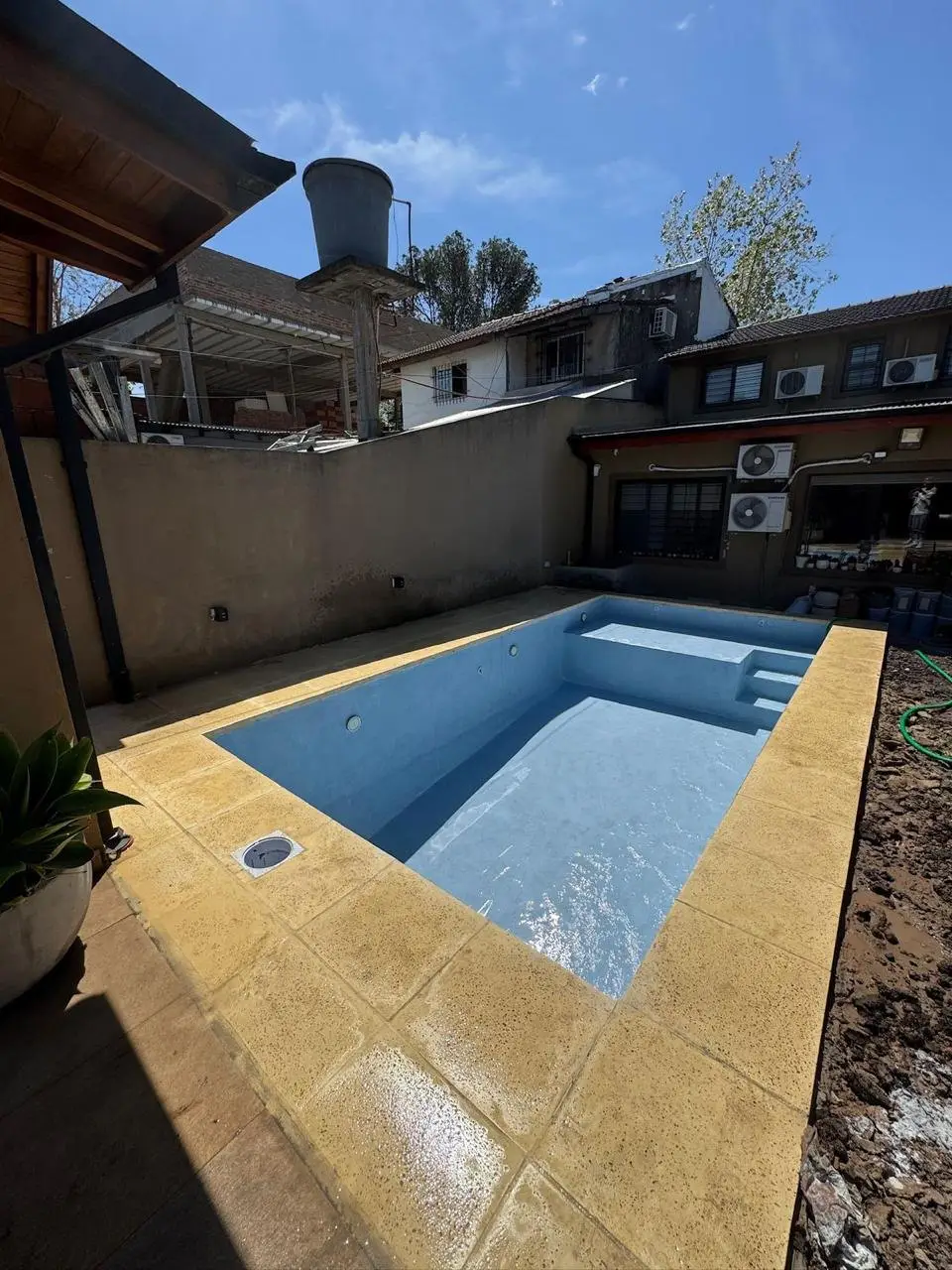 Piscina en pleno llenado, con los escalones de entrada a la vista