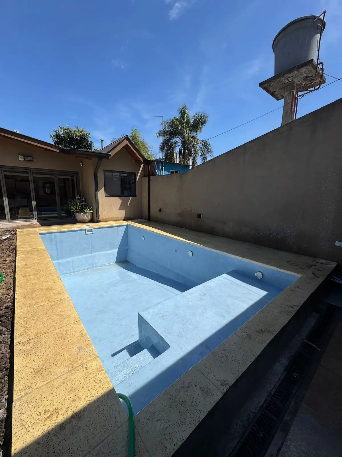 Piscina vacía con la terminación celeste lista, antes del llenado