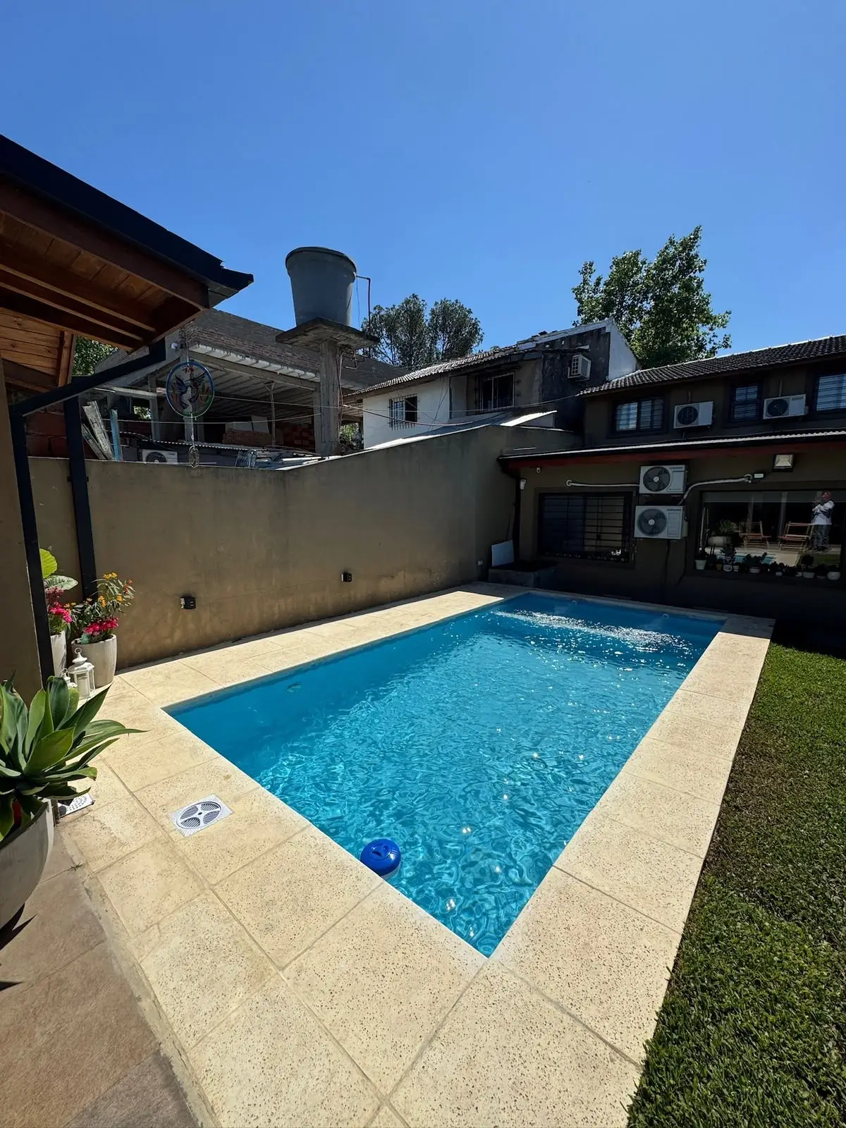 Piscina terminada con el solado claro que ocupa el resto del patio