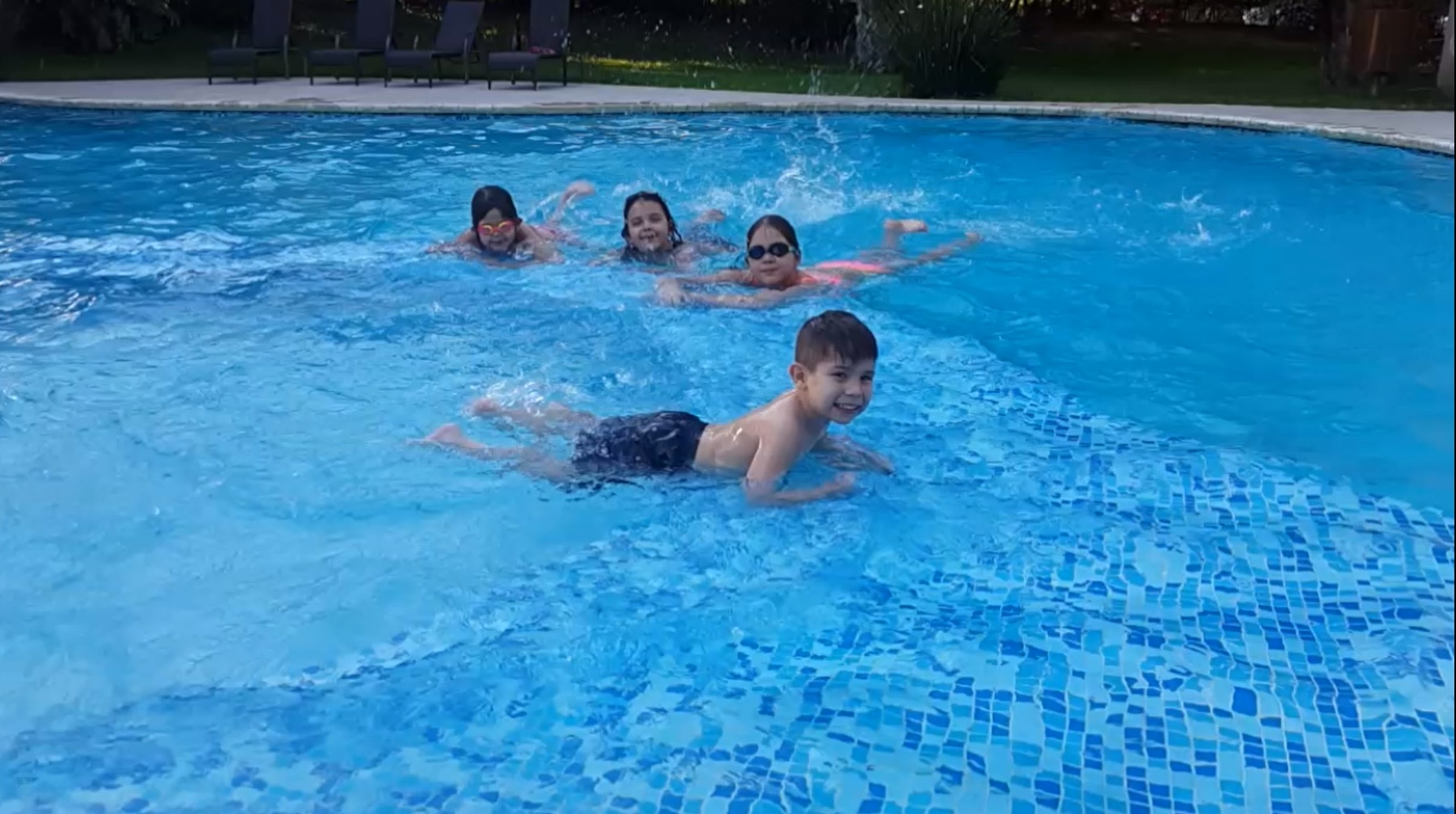 Chicos nadando en una piscina con venecitas