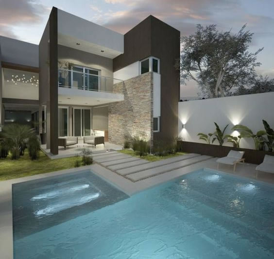 Casa moderna con muro de piedra y piscina iluminada al atardecer